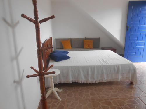 1 dormitorio con 1 cama y puerta azul en Apartamento perto de praia Dos Anjos 2 en Arraial do Cabo