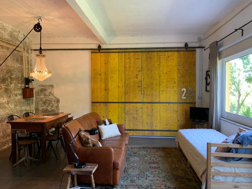 a bedroom with a yellow wall and a bed and a desk at Loft - Casinha à Porta in Arouca
