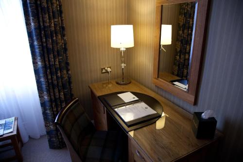 a hotel room with a desk with a lamp and a telephone at Burt's Hotel in Melrose