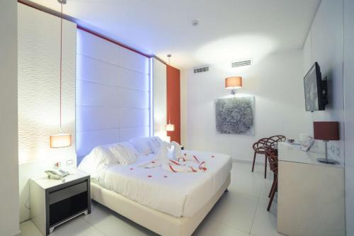 a bedroom with a large white bed and a table at Best Western Plus Hotel Perla Del Porto in Catanzaro Lido