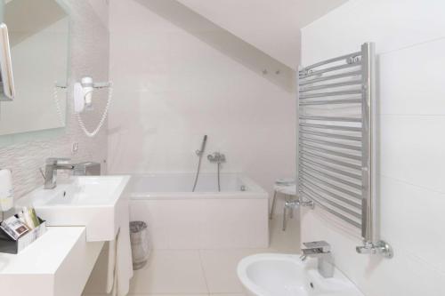 a white bathroom with a sink and a bath tub at Best Western Plus Hotel Perla Del Porto in Catanzaro Lido