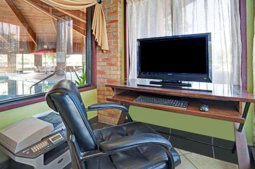 a computer sitting on a desk with a chair at Baymont by Wyndham Monroe in Monroe
