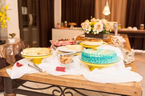 ein Tisch mit Kuchen und anderen Desserts darauf in der Unterkunft Natalina Pousada & Restaurante in Nova Trento