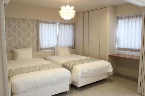 a bedroom with two beds and a chandelier at Hotel Flap Resort in Chatan