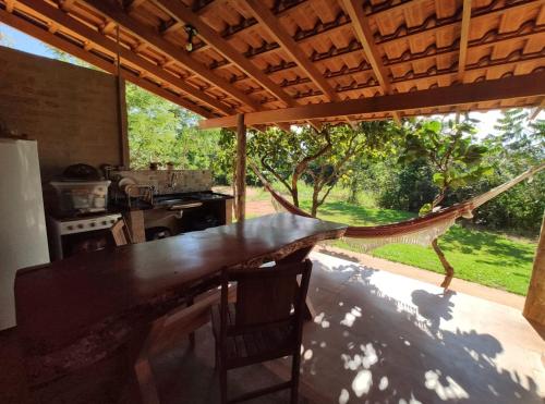 une cuisine avec une grande table en bois et un hamac dans l'établissement Céu da Canastra, à Delfinópolis