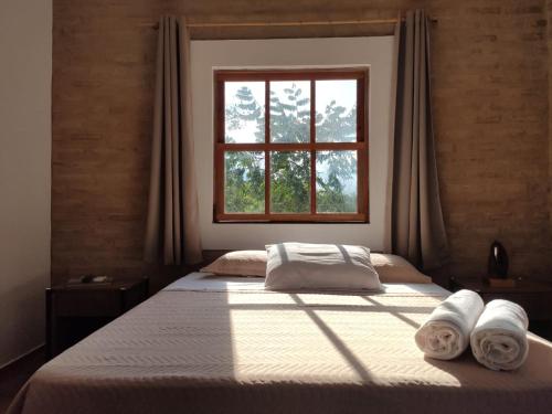 um quarto com uma cama com toalhas em Céu da Canastra em Delfinópolis
