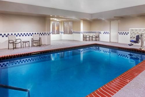 a pool with chairs and tables in a hotel room at La Quinta by Wyndham Hopkinsville in Hopkinsville