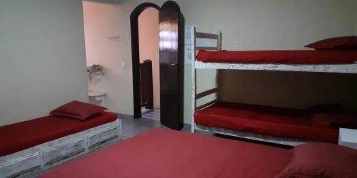 a room with two bunk beds and a red bed at VILLA GARDEN - Suites in Maresias