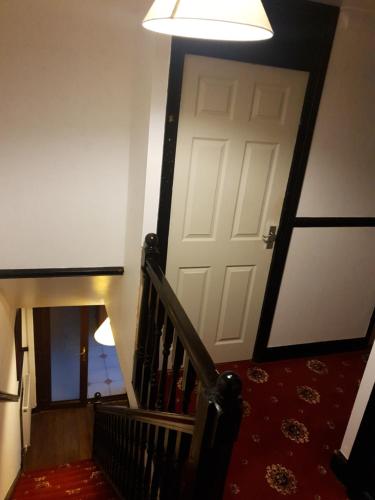 a stairway with a white door and a red carpet at Shergold House in Swindon