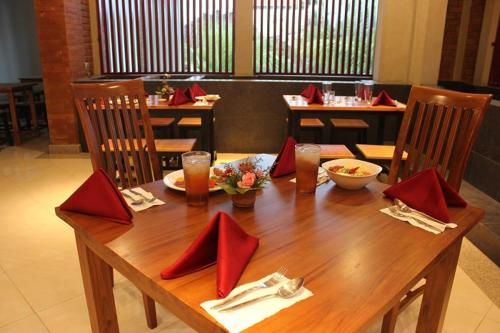 タバナンにあるThe Sarining Hotelの木製テーブル(上に赤いナプキン付)