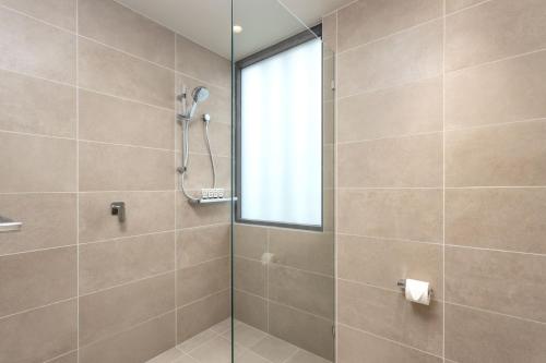 a bathroom with a shower with a glass door at Club Old Bar Motel in Old Bar