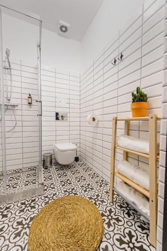 a bathroom with a shower and a toilet and a rug at BOHO HOUSE in Ustrzyki Dolne