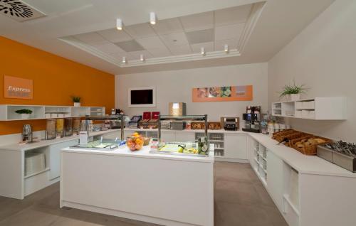 a large kitchen with white counter tops in a room at Holiday Inn Express Antwerpen City North by IHG in Antwerp