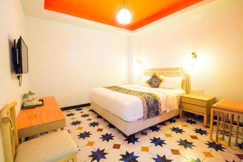 una habitación de hotel con una cama y una mesa y una habitación en Hotel Hilal, en Cyberjaya