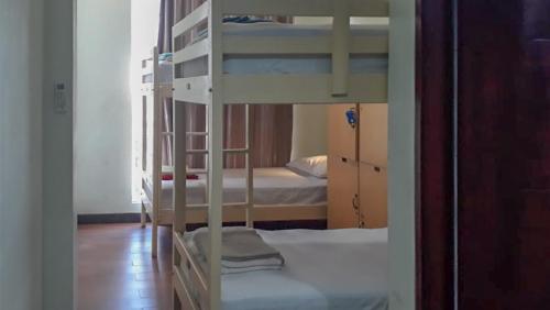 RedDoorz Hostel @ Manado Green Hostel في مانادو: غرفة بسريرين بطابقين في غرفة