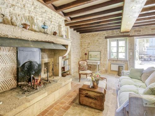ein Wohnzimmer mit einem Kamin und einem Sofa in der Unterkunft Burgundian Farmhouse in Talon with Fireplace in Talon