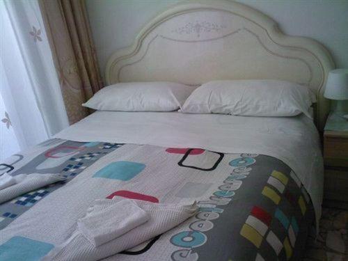 a bed with a blanket and pillows on it at Roma Prince Inn B&B in Rome