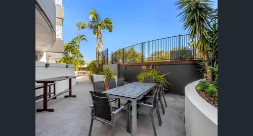 a table and chairs on a patio with a pool table at The Wellington Apartment Hotel in Brisbane