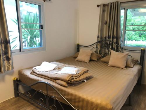 a bed with two towels on it in a bedroom at ทับศิลารีสอร์ท Tubsila Resort in Chongsadao