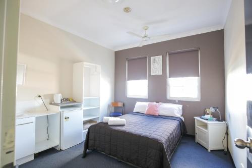 a small bedroom with a bed and a desk at Bayview Hotel Woy Woy in Woy Woy