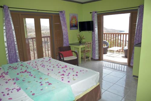 Tropical Paradise View في Anse La Raye: غرفة نوم بها سرير عليه زهور