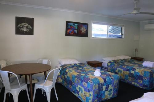 a hotel room with two beds and a table at Agnes Palms Accommodation in Agnes Water