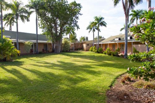 a yard in front of a building with palm trees at The Kimberley Grande Resort in Kununurra