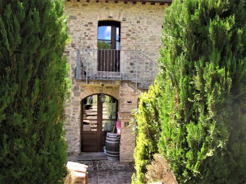 a building with a balcony and a door with trees at La Pietra Rara B&B in Montone