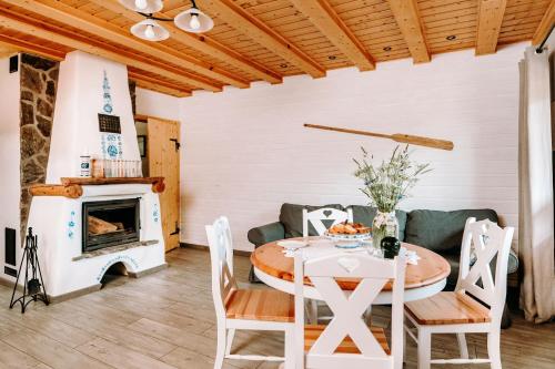 a dining room with a table and a fireplace at Widokówka in Pokrzydowo