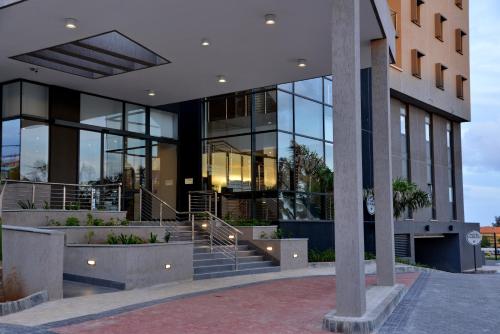 a large building with glass windows and stairs at City Lodge Hotel Maputo, Mozambique in Maputo