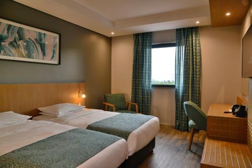 a hotel room with two beds and a window at City Lodge Hotel Maputo, Mozambique in Maputo