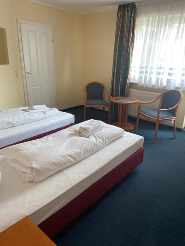 two beds in a hotel room with chairs and a window at Boutique Hotel Villa Stockum in Düsseldorf