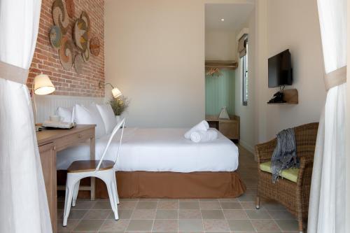 a hotel room with a bed and a desk and a chair at La Em Boutique Villa in Da Lat