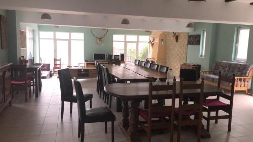 a dining room with a wooden table and chairs at Casa Pescarului in Podişu