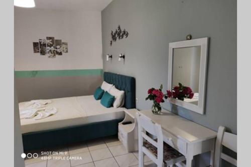 a bedroom with a bed and a table and a mirror at Iason studio 2 in Patitiri