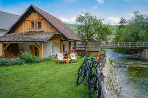 two bikes parked next to a house next to a river at Hike & Bike Chalet in Bohinj