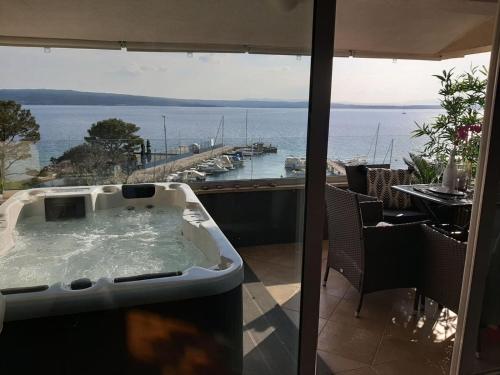 a hot tub on a patio with a view of the ocean at Apartments Sax in Crikvenica