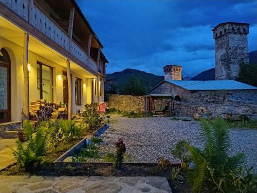 a house with a garden in front of it at Bapsha Guesthouse in Mestia