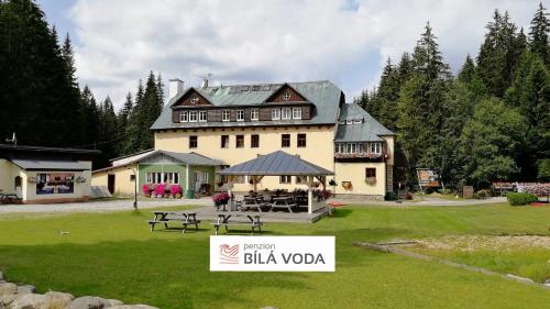 a large house with a sign in front of it at Penzion Bílá voda in Harrachov