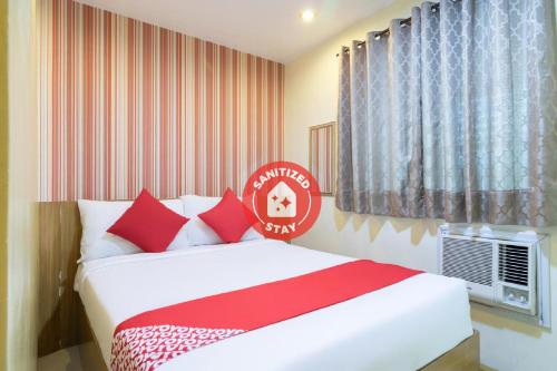 a bedroom with a bed with red and white pillows at Starlight Bed and Breakfast in Manila