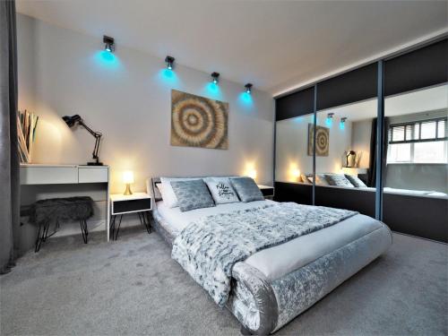 a bedroom with a large bed with blue lights on it at Beautifully Boutique 4 Sleeper Eton High Street in Windsor