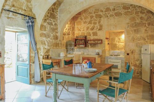 a kitchen with a wooden table and chairs at Villa Ta Marija in Xagħra
