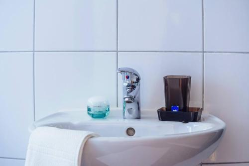 La salle de bains est pourvue d'un lavabo avec un robinet et un verre. dans l'établissement Apartmani Simundic, à Trogir