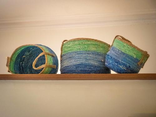 three baskets are sitting on a wooden shelf at Pension Ciudadela in Barcelona