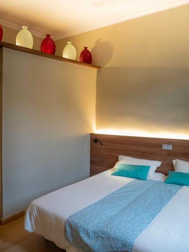 a bedroom with a bed with red vases on the wall at Pension Ciudadela in Barcelona