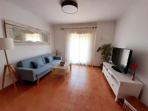 sala de estar con sofá azul y TV en Encanto de Tarifa, en Tarifa