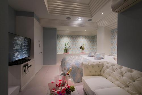 a bedroom with a bed and a couch and a tv at Hotel Eldia Machida -Adult Only in Kami-seya