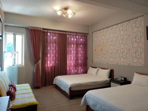 花蓮市的住宿－柚子之家和平民宿，酒店客房设有两张床和窗户。