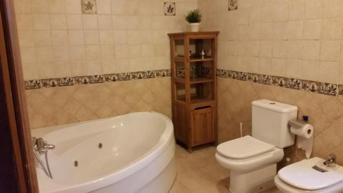 a bathroom with a tub and a toilet and a sink at casa cacheiras in Teo