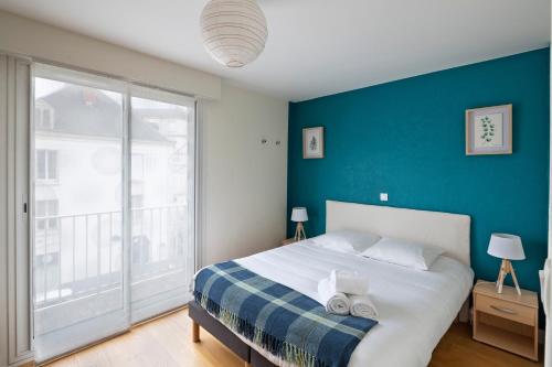 a bedroom with a large bed with a blue wall at Le Singulier - 2 chambres et parking in Nantes